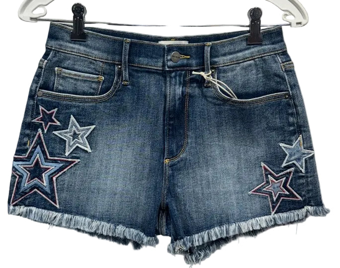 Blue denim shorts with star patches on a hanger against a neutral background