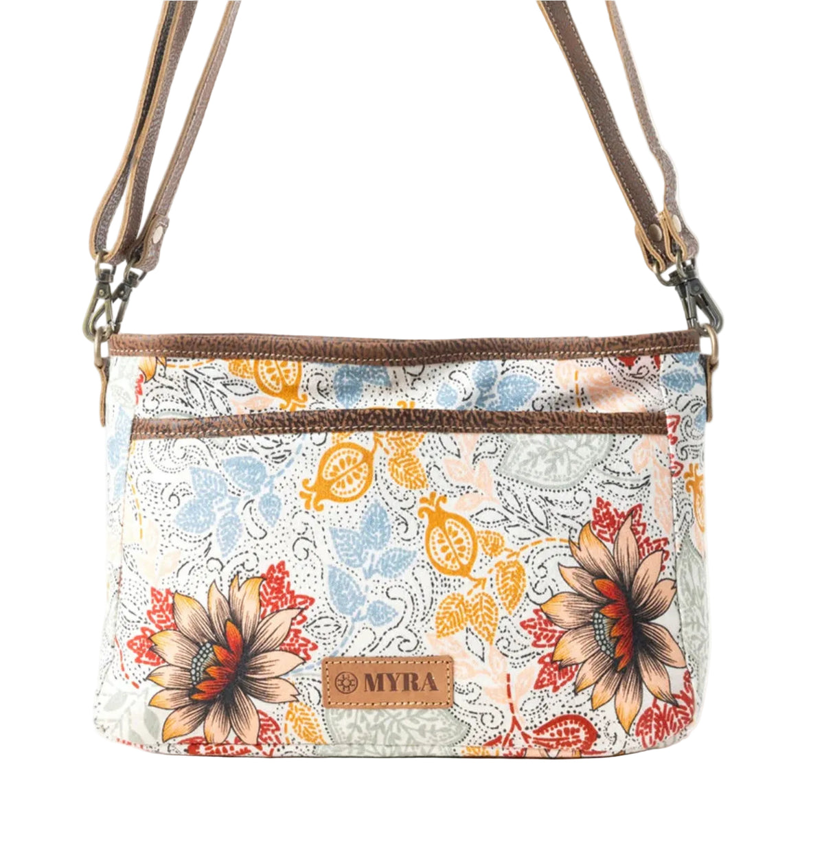 A crossbody handbag with a cream-colored background and a colorful floral paisley pattern in orange, blue, and red. It features brown straps and trim, a top zipper, and a small brown leather patch with the brand name 'MYRA'.
