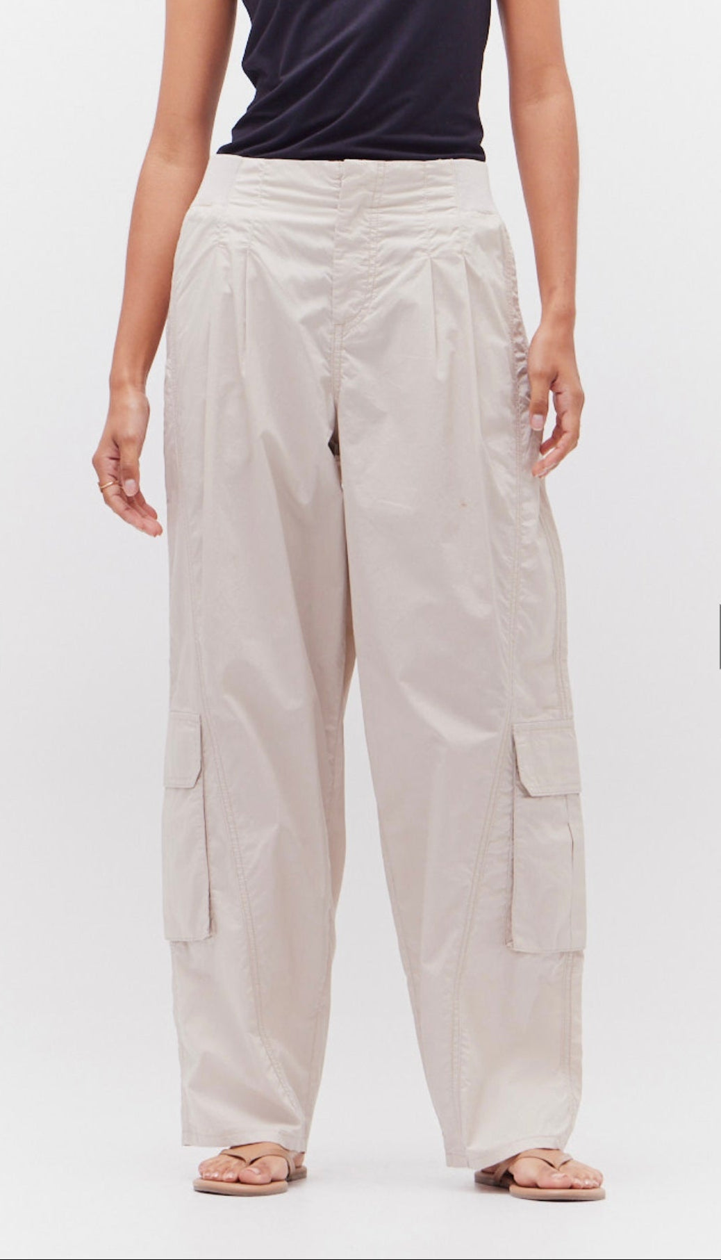 A model wearing beige 100% cotton poplin cargo pants with multiple pockets.